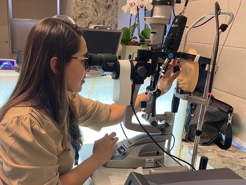 Dra. Bárbara Oliveira em treinamento de laser oftalmológico na lâmpada de fenda, com simulador de olho artificial